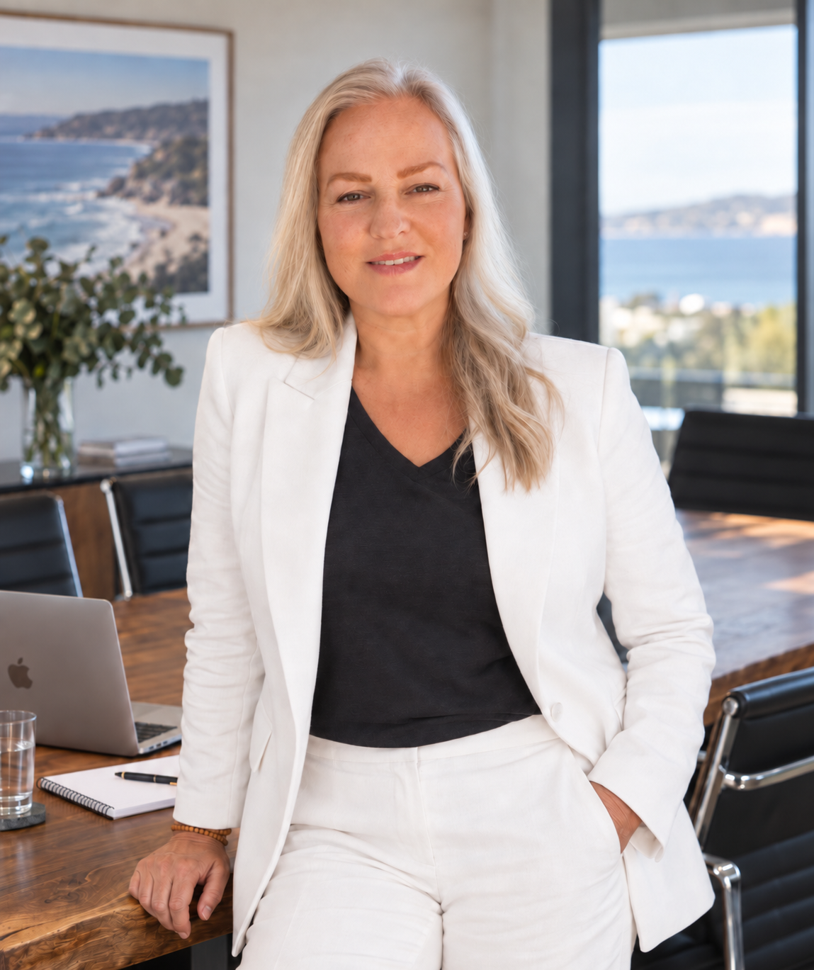 Tania Gorry, founder of Whole Warrior Network, wearing a white suit in a light-filled coastal office